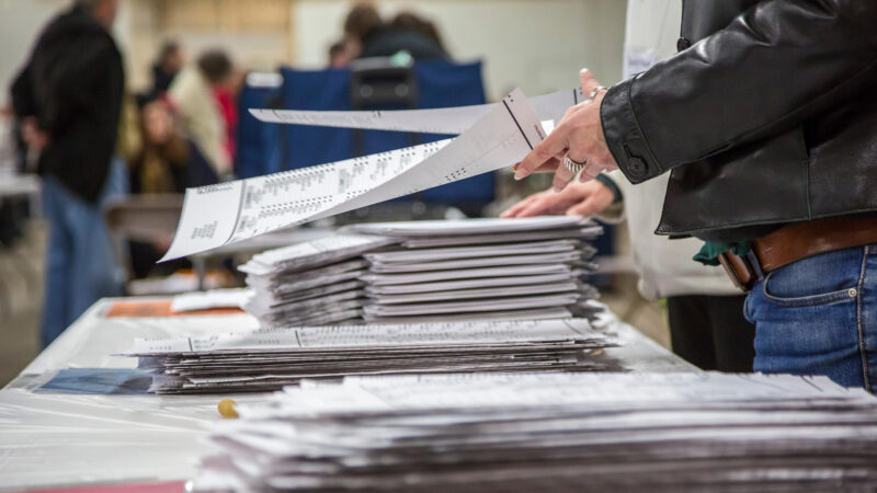 A hand on a ballot during an election.