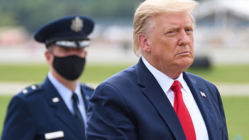 Trump with a US army officer in the background.